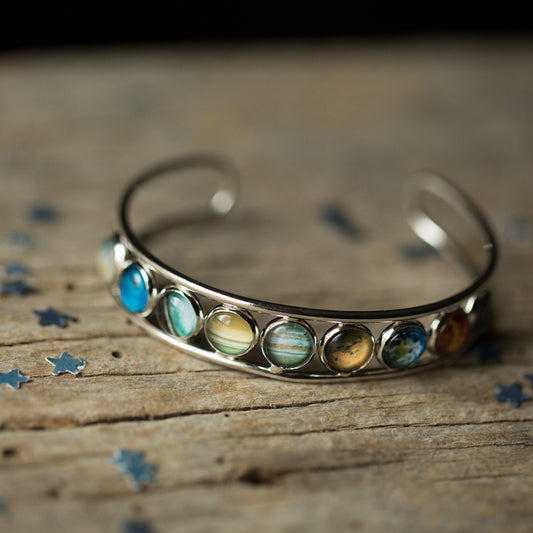 "Discover the Beauty of Our Solar System with a Stunning Silver Bangle Bracelet"